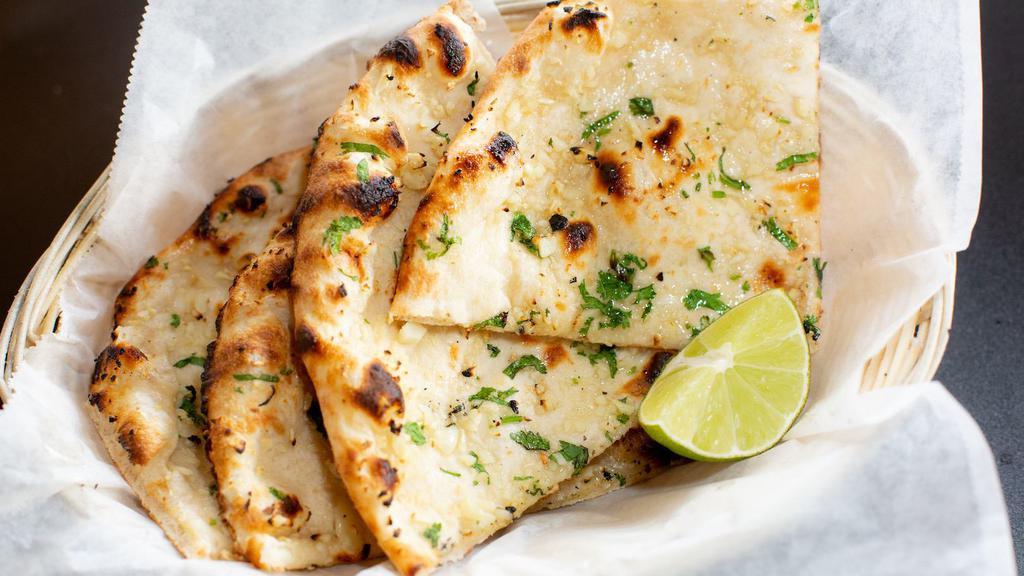 Garlic Naan · Leavened wheat flour dough flattened, topped with chopped garlic and baked in oven.