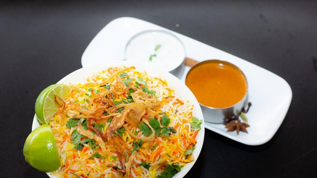 Lamb Biryani · Boneless shoulder lamb pieces cooked curry sauce and mixed with flavored basmati rice. Served with raita and salan. Allergy Indicators: Dairy
