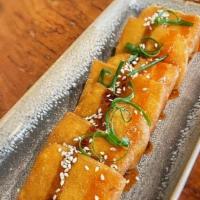 Fried Yellow Bean Tofu · Homemade tofu made with fresh yellow beans. Crisp on the outside, silken center. Served with...