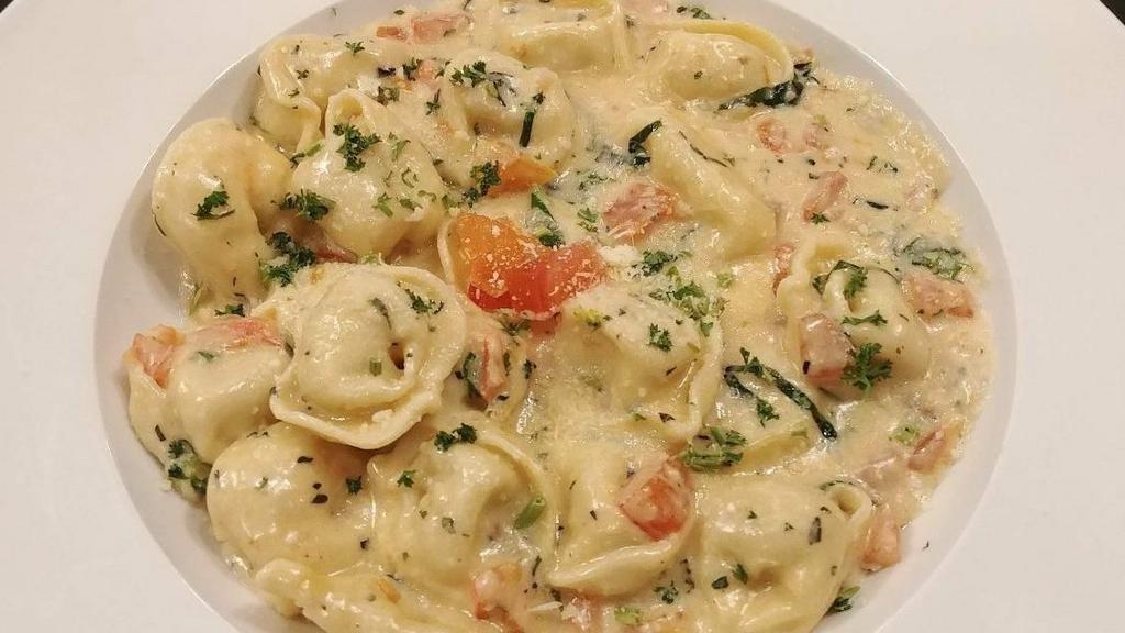 Tortellini · Tortellini filled with 3 cheeses sautéed with garlic, tomato and black olives and herbs on cream sauce