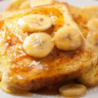 Banana French Toasts · Fresh fluffy french toasts topped with bananas cut into 3 slices with butter and syrup.