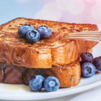 Blueberry French Toasts · Fresh fluffy french toasts topped with blueberries cut into 3 slices with butter and syrup.