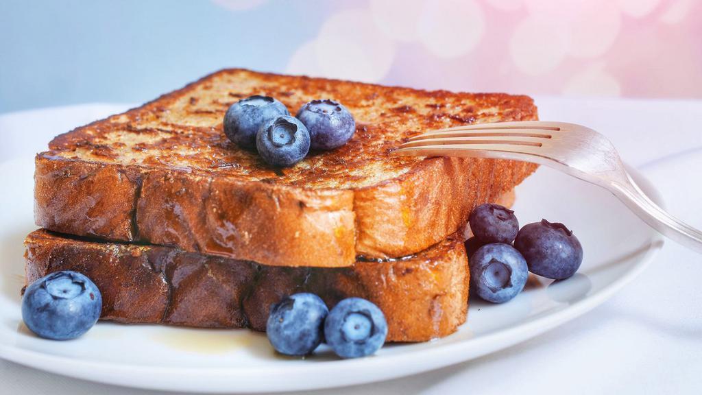 Blueberry French Toasts · Fresh fluffy french toasts topped with blueberries cut into 3 slices with butter and syrup.
