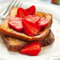 Strawberry French Toasts · Fresh fluffy french toasts topped with strawberries cut into 3 slices with butter and syrup.