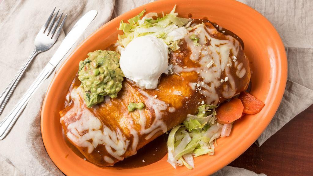 Super Famoso Burrito · Big burrito topped with enchilada sauce, cheese, sour cream & guacamole. Served with rice, beans & cheese inside. Garnished with lettuce, pico de gallo & Cotija cheese.