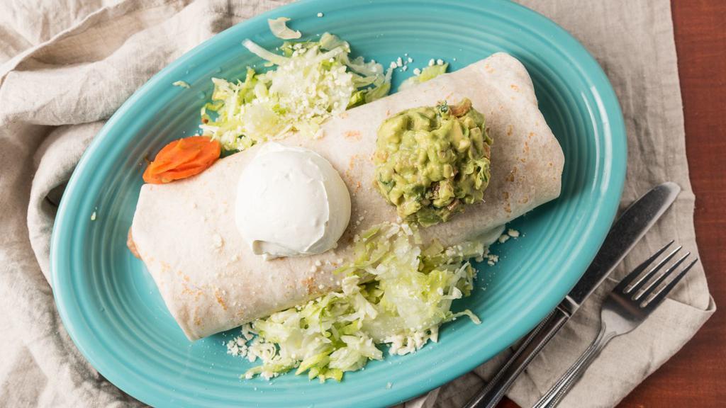 Super Burrito · Big burrito topped with guacamole & sour cream. Served with rice, beans & cheese inside. Garnished with lettuce, pico DE gallo & Cotija cheese.