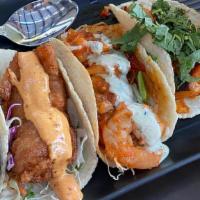 Tacos del Mar · A medley of three seperate seafood tacos. Crispy tempura codfish, topped w/ coleslaw, pico o...