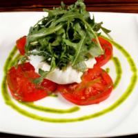 Burrata · Creamy mozzarella cheese served with tomatoes in a basil oil and arucola.