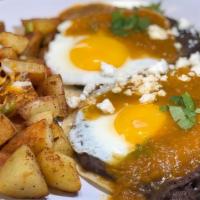 Laura's Huevos Rancheros · Eggs and refried black beans on soft but crispy corn tortillas, topped with ranchero sauce.