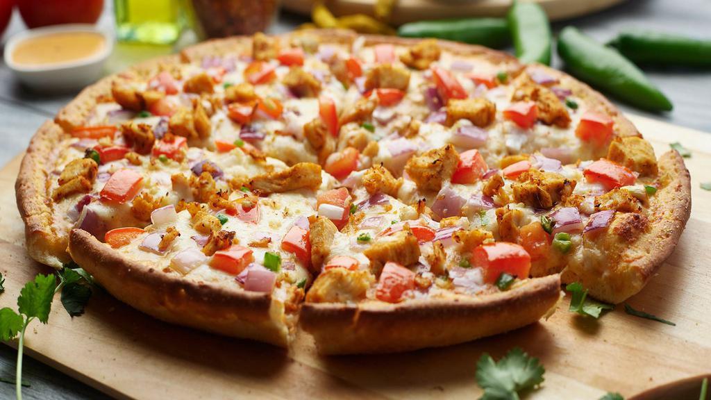 Butter Chicken Pizza Twist · This pizza has our signature butter sauce, our signature All-Natural Butter Chicken Breast, fresh mozzarella cheese, crisp red onions, juicy tomatoes, fresh diced; garlic, ginger & green chilies, garnished with fresh cilantro.