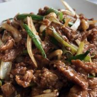 Mongolian Beef · Succulent beef tenderloins garnished with scallions and rice noodles.