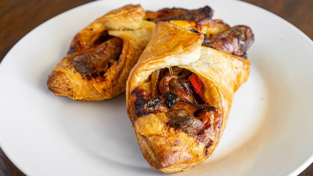 Sausage Roll · Seared bratwurst with a layer of gooey Cheddar cheese, tender peppers and onions, all held together in a flakey boat  of puff pastry.