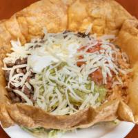 34. Taco Salad · Deep fried flour tortilla filled with whole beans, rice, lettuce, guacamole, sour cream, sal...