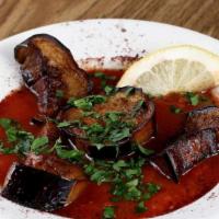 Moussaka · Sliced eggplant topped with tomato sauce.