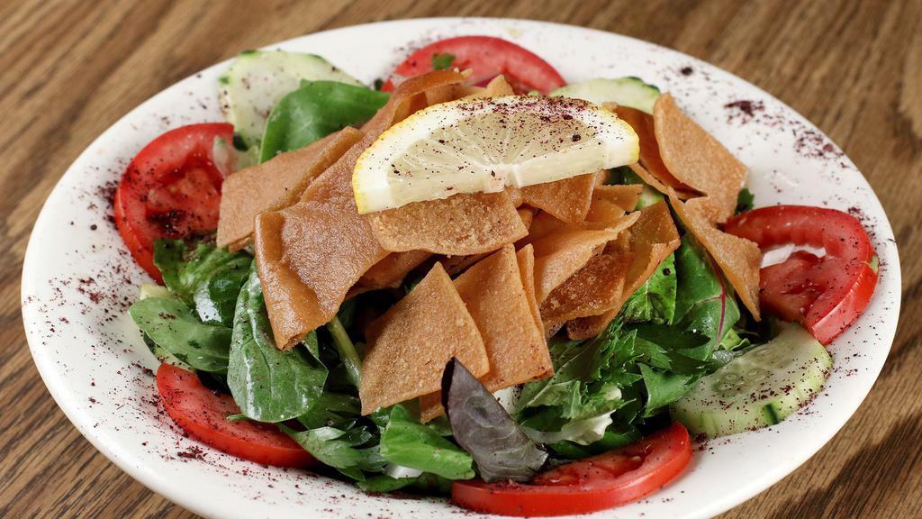 Fattoush Salad · Diced cucumber, lettuce and tomato pieces mixed with mint and vinegar, topped with oven-toasted pita.