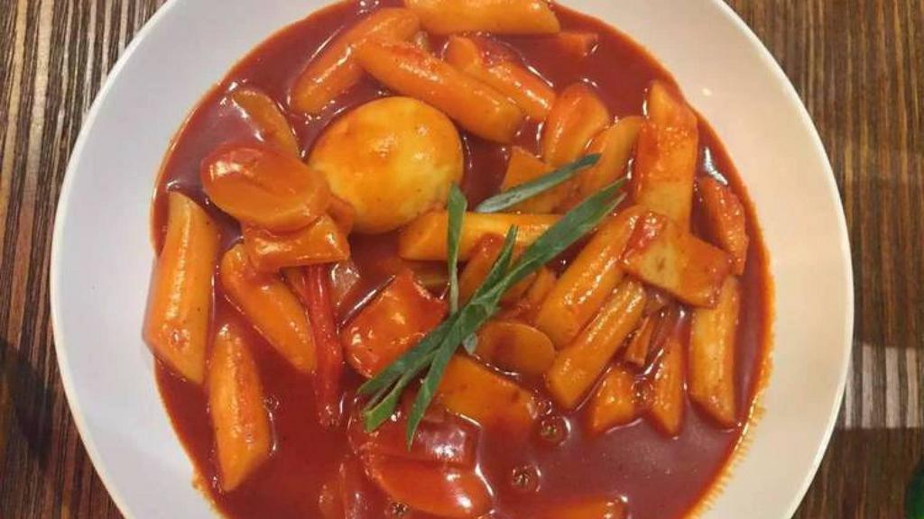 Spicy Rice Cakes (Tteokbokki) · Rice cakes in a spicy sauce with fish cakes, sausages, and green onion.