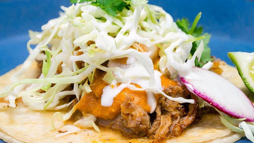 Carnitas Taco · slow braised pork, chipotle salsa, cabbage slaw, baja crema