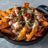 Patatas Queso y Chorizo · fries tossed in pimentón salt with melted manchego cheese sauce topped with crispy chorizo f...