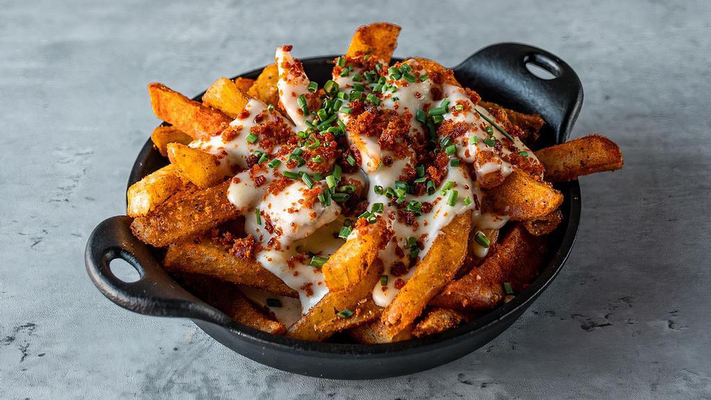 Patatas Queso y Chorizo · fries tossed in pimentón salt with melted manchego cheese sauce topped with crispy chorizo flakes