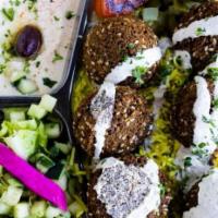 Falafel Rice Plate · Fresh home made falafels on a bed of rice, includes hummus, salad, pickles/onions, pita