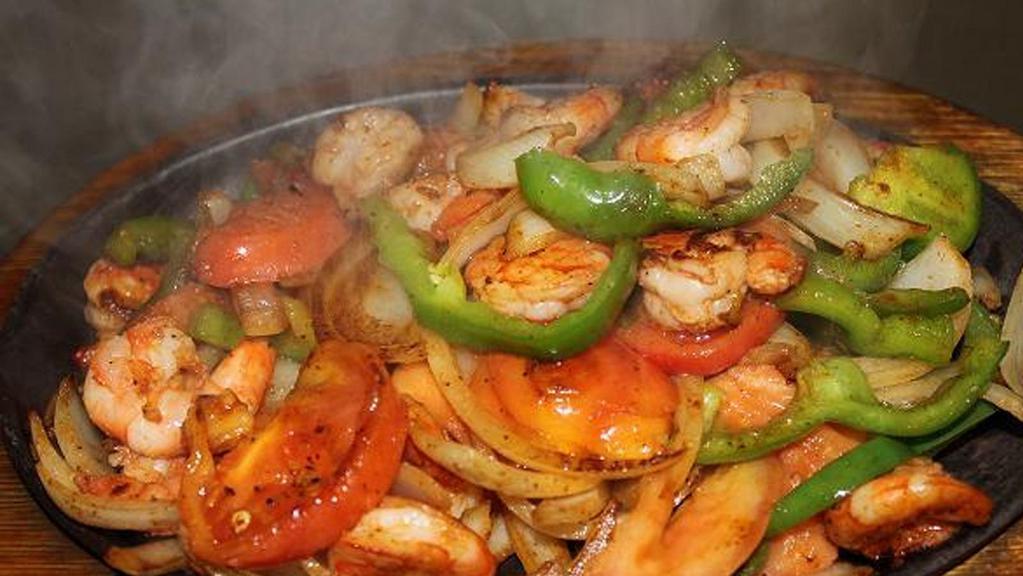FAJITAS DE CAMARON · GRILLED SHRIMP WITH BELL PEPPERS
AND ONIONS SERVED ON A 
SIZZLING SKILLET.