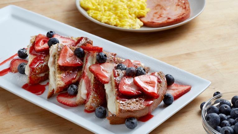 Pain Perdu Grande · Stuffed brioche French toast filled with orange marmalade and cream cheese blend topped with fresh berries and strawberry purée. (1150 cal) .