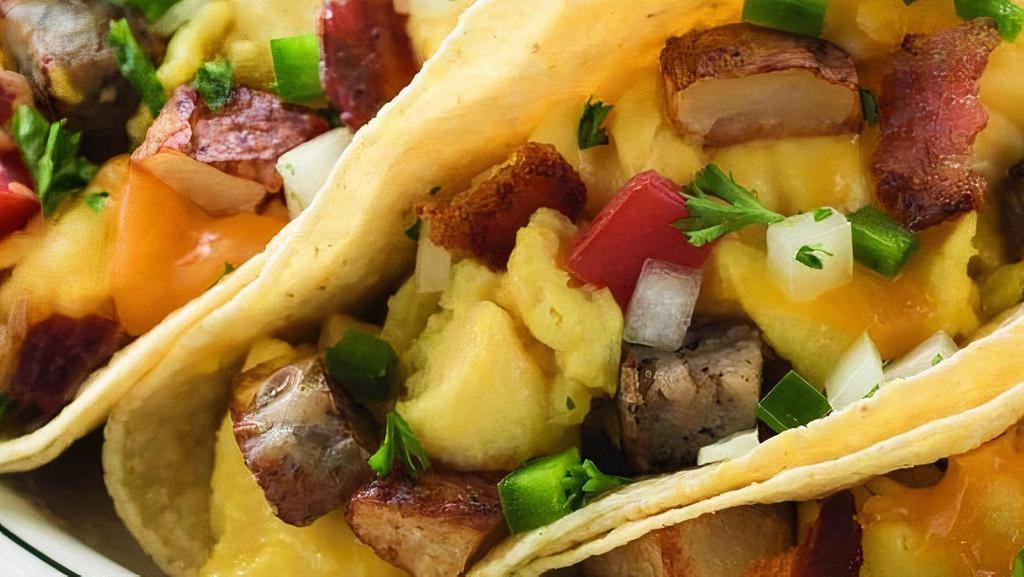 Farmhouse Tacos · Hickory-smoked bacon, sausage, scrambled eggs, roasted potatoes, cheddar cheese, jalapeno, tomato, onion and cilantro in flour tortillas. Served with salsa. (1140 cal)