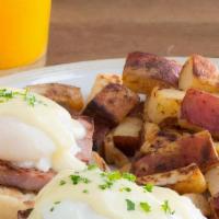 Eggs Benedict · Hickory-smoked ham and poached eggs topped with hollandaise sauce on a grilled English muffi...