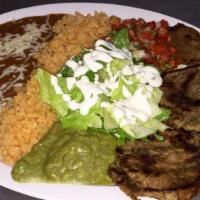 Plate · Choice of meat, beans, rice, guacamole, salsa ranchera, sour cream, lettuce, with four corn ...