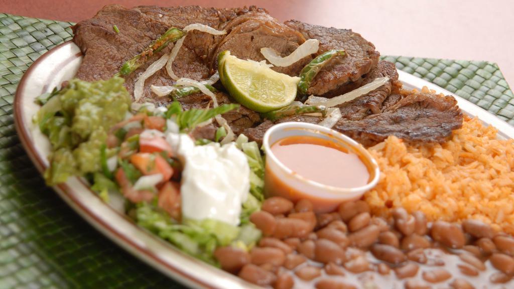 Steak Dinner Plate · Top Steak served with Grilled onions, guacamole, sour cream, pico gallo, Rice, Beans and Tortillas.