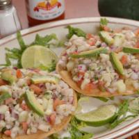 Ceviche Tostada · Fresh Tilapia Fish cooked in a lemon Juice with Cucumbers, Tomatoes, Red Onions, Cilantro an...