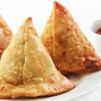 Vegetarian Samosa · Crispy fried pastry filled with green peas, potatoes, cilantro, served with mint and tamarin...