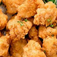 Cauliflower Fritters · Fried Cauliflower on a bed of cabbage with choice of drizzled sauce or sauce on the side