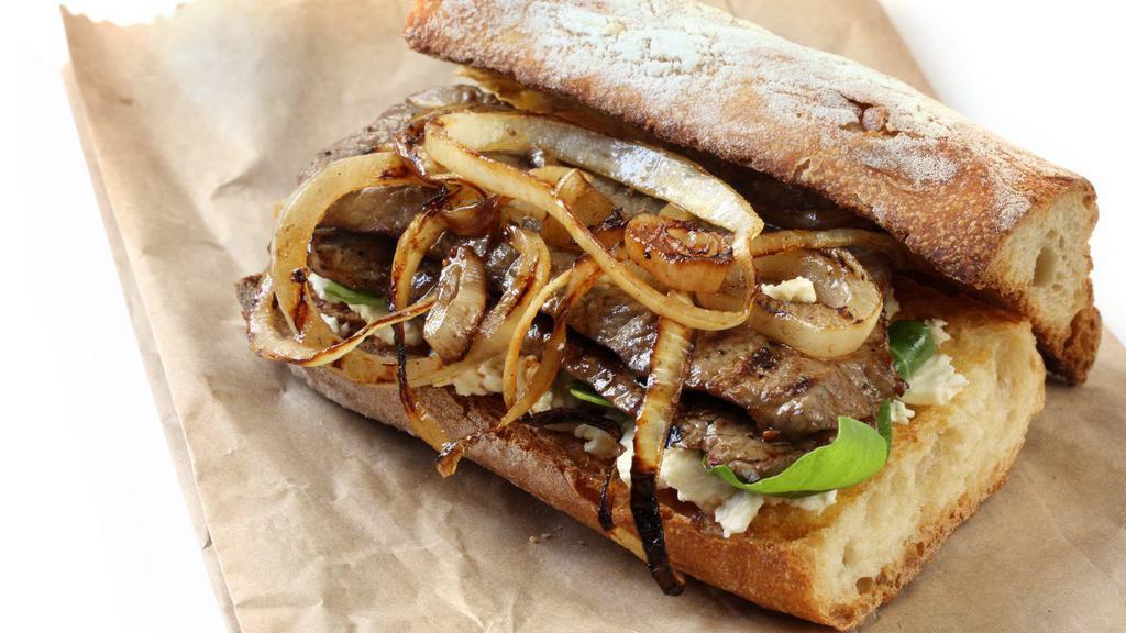 Steak Sandwich · New York steak, grilled onions, tomatoes, lettuce, and garlic mayonnaise on French roll.