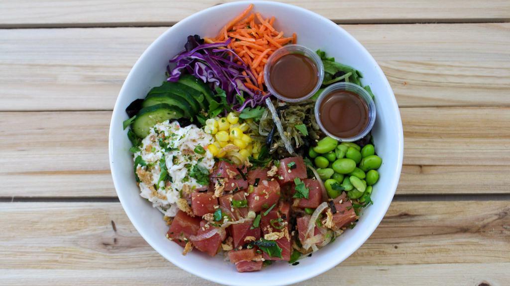 Wasabi Soy Tuna Poke Bowl · Wasabi Soy Tuna Poke served over rice & mixed greens with krab salad, seaweed salad, cucumber, corn, carrot, red cabbage, edamame, crispy onion, furikake and cilantro. With just a subtle hint of Wasabi, this bowl is not spicy but still packed with flavor.