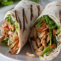 Chicken Shawarma · Seasoned sliced shawarma chicken with tahini, lettuce, and tomatoes topped with our house ga...