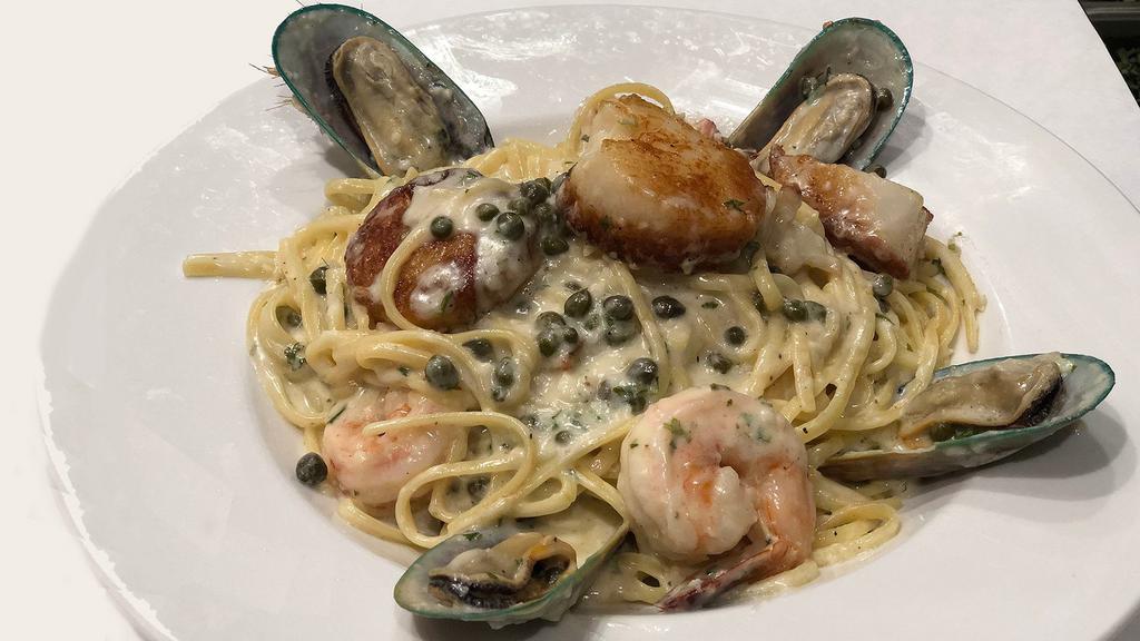 Scallop, Prawn & Mussel Picatta · A perfect combination of seafood, capers and lemon sauce. Served over linguini pasta.