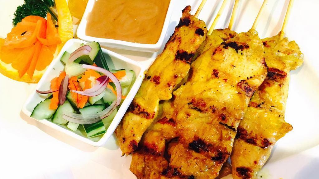 Chicken Satay · Grilled chicken with peanut sauce and cucumber salad.