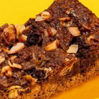 7 Layer Bar · With an almond cookie crust, then layered with house-made caramel, coconut chips, brownies p...