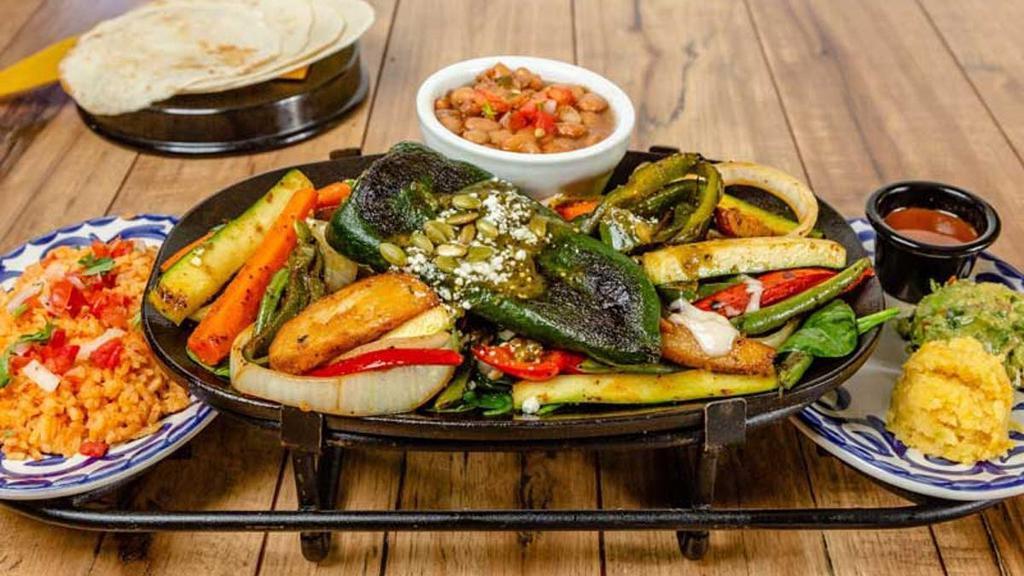 VEGGIE FAJITAS · Fresh vegetables, rosemary and mint leaves with a grilled chile relleno. Served with rice, frijoles de la olla, guacamole, sweet corn cake and choice of flour or corn tortillas.
