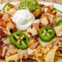 NACHOS SUPREMOS - CHICKEN · Chicken on a mound of warm chips, melted cheese, refried beans and guajillo chile sauce topp...