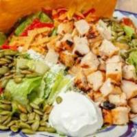 Grilled Chicken Taco Salad · Homemade tostada taco shell filled with romaine lettuce, refried beans, pico de gallo, cotij...