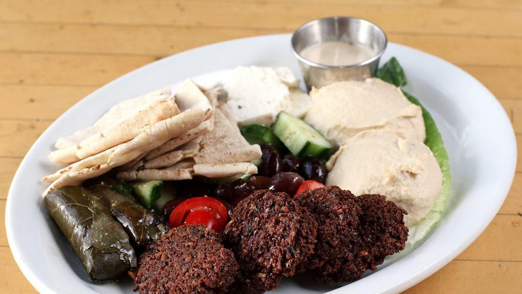 Middle-Eastern Sampler Platter · With Falafels, Hummus, Pita Bread, Olives, Feta, Dolmas, Cucumbers, Tomatoes and Tahini Sauce.