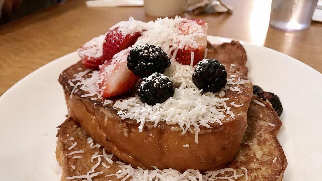 Coconut French Toast · Hawaiian bread dipped in coconut cream batter, topped with mascarpone-jam blend, shredded coconut and berries.