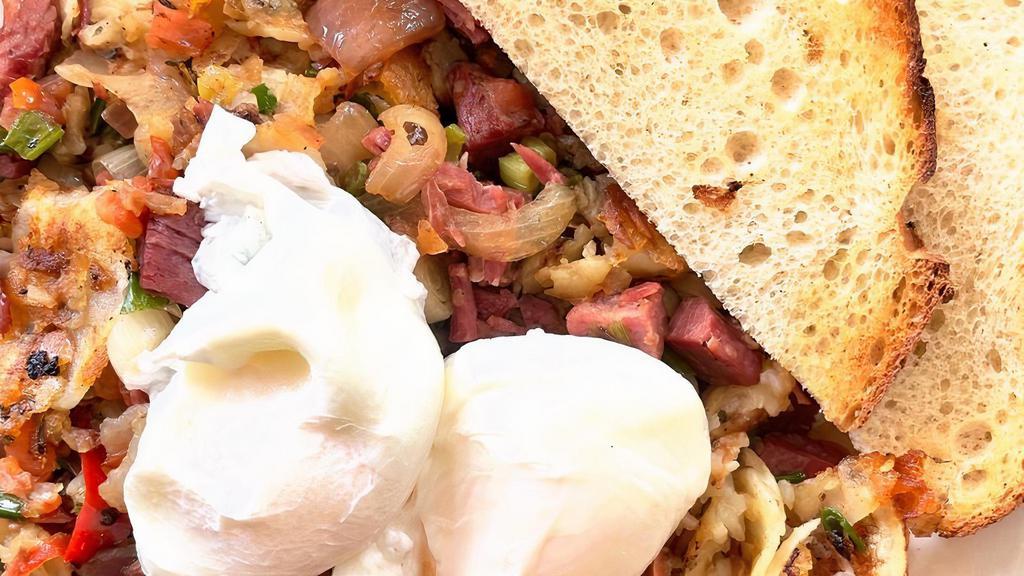 Homemade Corned Beef Hash · Corned beef sautéed with red bell pepper, onion and potato, topped with two poached eggs and served with toast.