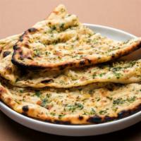 Garlic Naan · Fresh made in house butter naan topped with chopped garlic baked in a clay oven.