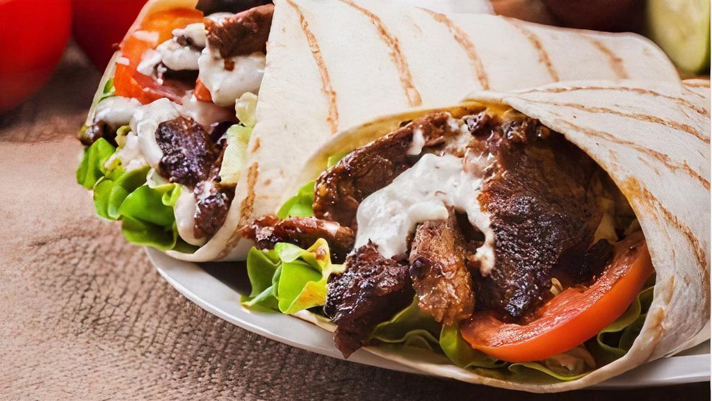 Steak et Fromage wrap · Marinated and grilled sliced steak with aioli, roasted red peppers, fresh onions, cheddar cheese, topped with baby spinach.