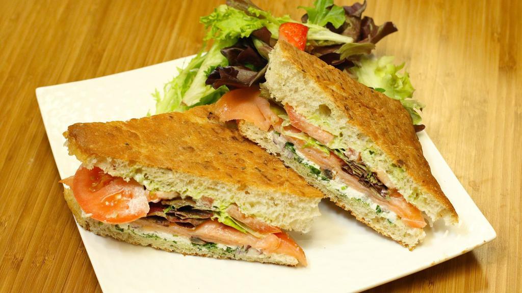 Smoked salmon  · Smoked salmon, pesto mayo, diced capers, diced olives, Swiss cheese, sliced tomatoes, organic mixed greens.