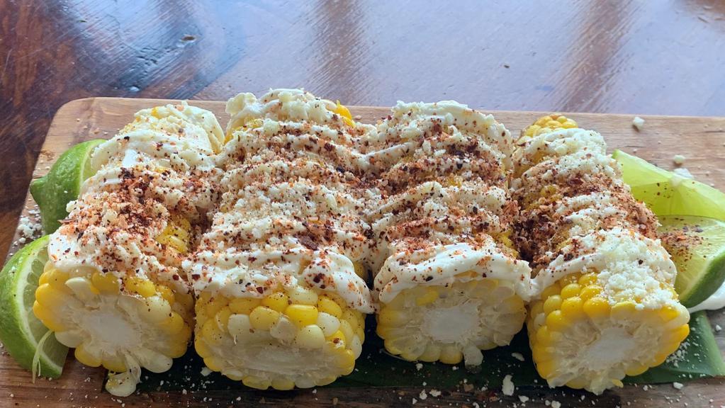 Esquite de Elote Vegan · 2 Mexican street corn cut in half, with vegan mayonnaise, vegan sour cream, queso vegan parmesan, and limes.