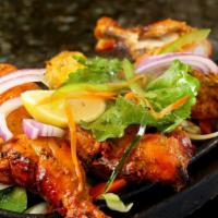 Chicken Tandoori · Chicken with bones marinated in yogurt and spices, broiled in the tandoor clay oven and serv...